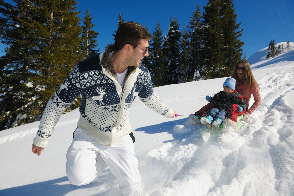 Winter season. Happy family having fun on fresh snow on vacation.